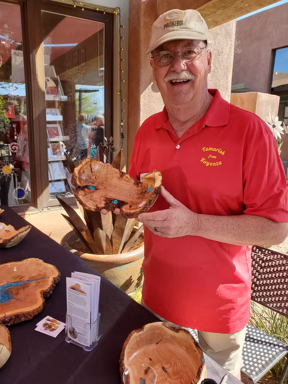 Barry Gray, of the Southern Utah Woodturner's Club, stands at a booth with his wooden art object offerings at an arts festival